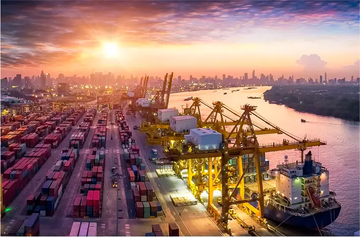 Cranes and containers in port during sunset