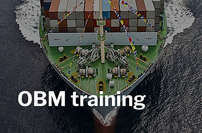 Aerial view of a container ship's bow at sea with the title OBM training.