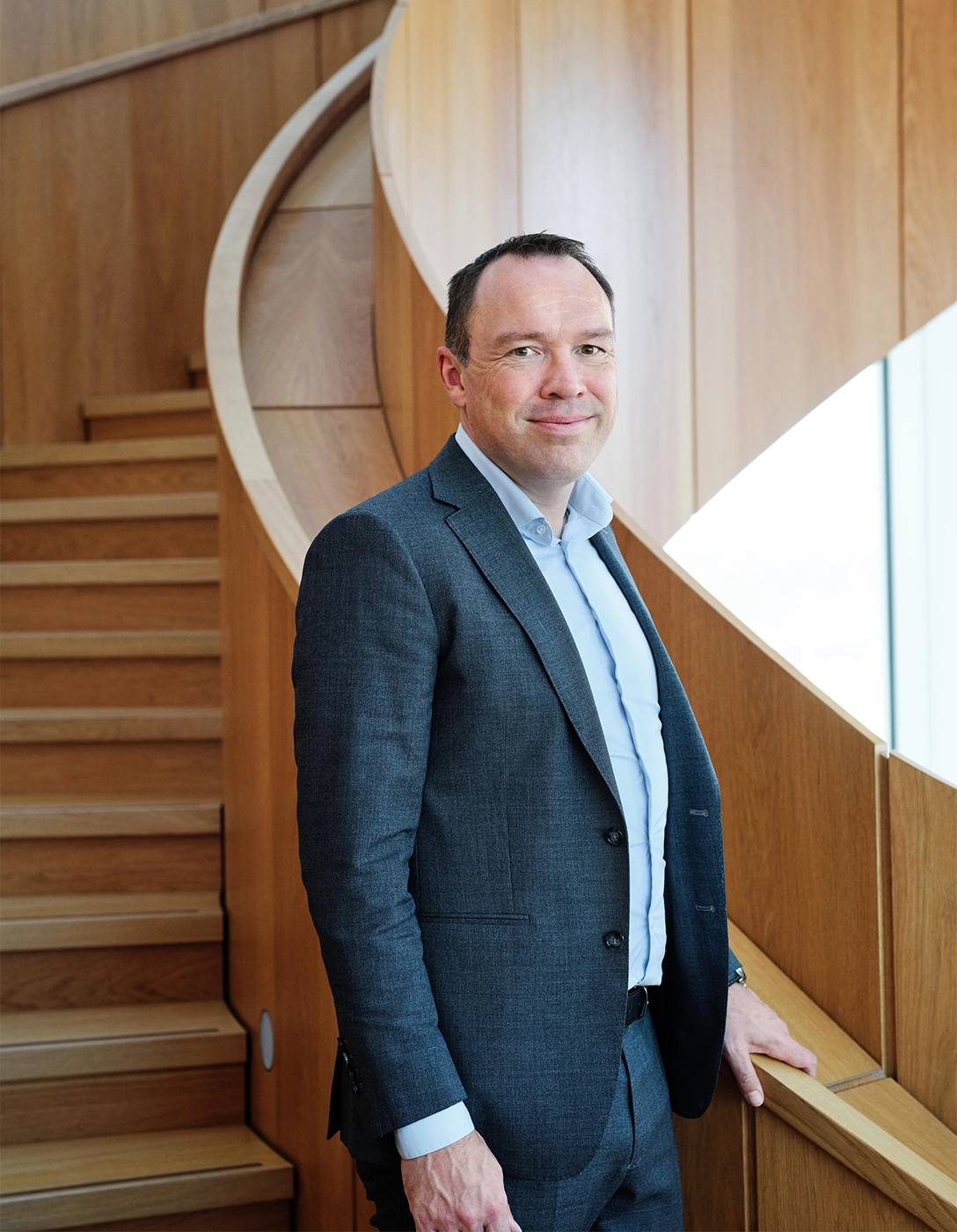 Michael Hansen, Hempel's CEO, standing on a staircase, smiling.