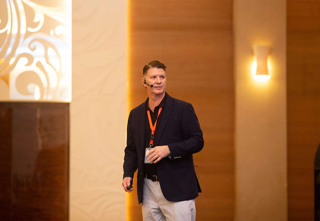 David Hunter, Segment Development Manager for CUI/High Heat & Insulation, speaks on stage at a coating technology seminar, wearing a headset and holding a small device.