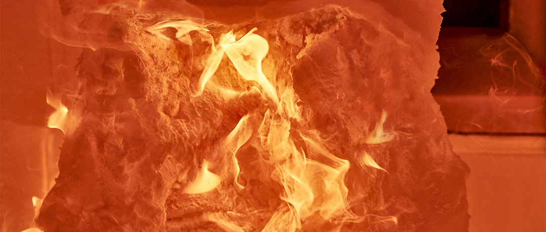 Intense flames consuming a material inside a furnace, part of a fire resistance test for passive fire protection.