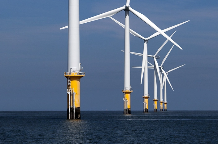 Row of offshore wind towers.