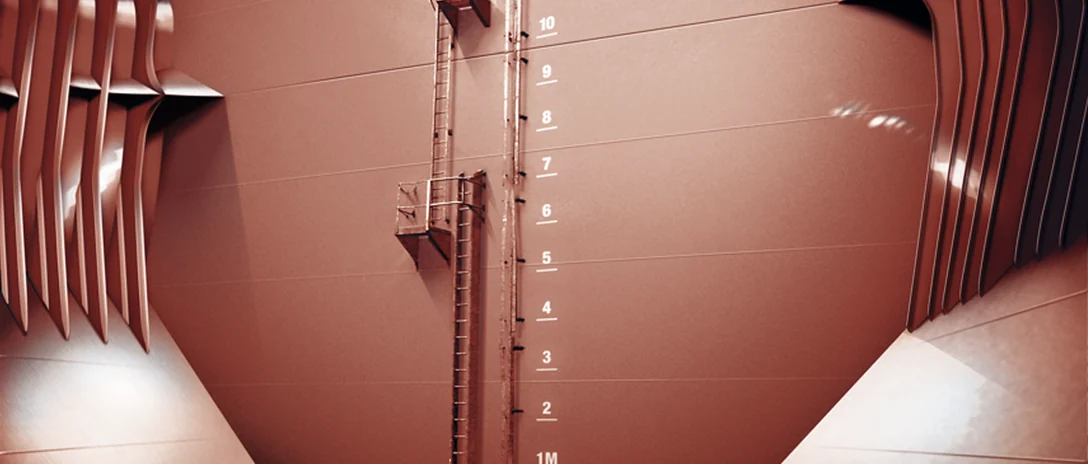 Interior of a coated cargo tank with a vertical ladder and depth markings from 1 to 10 metres.