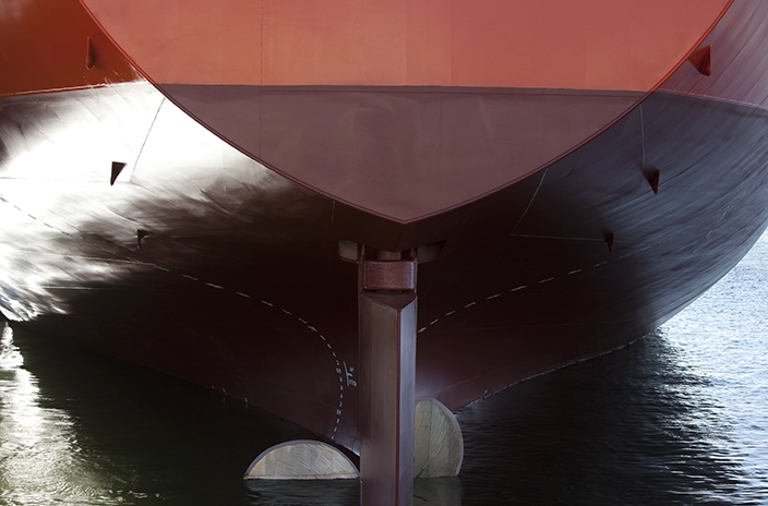  Close-up of a red ship’s rudder and hull.