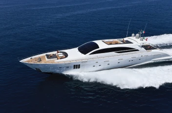 A sleek white yacht speeding through the ocean, leaving a trail of white foam behind.
