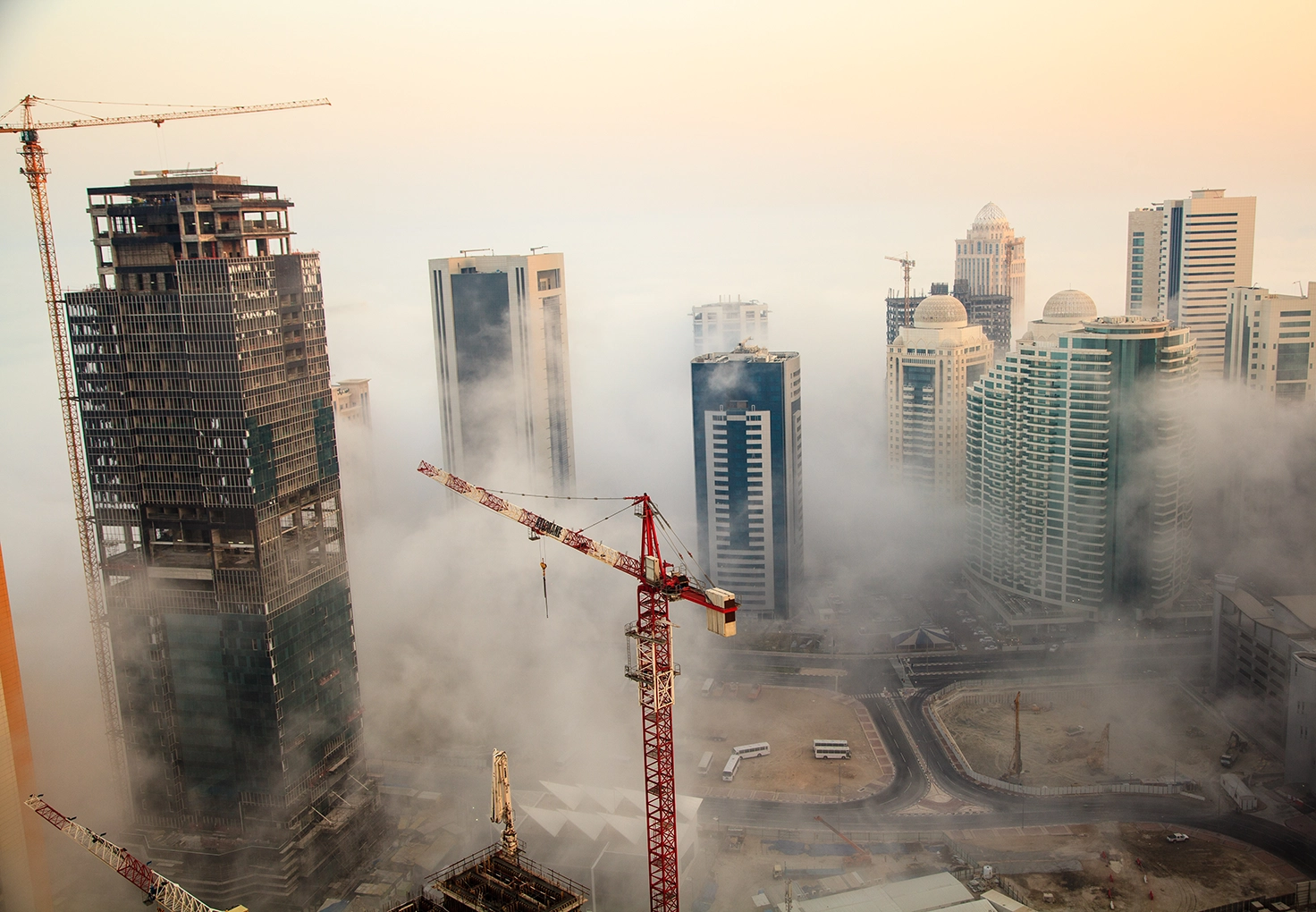  A city skyline with a construction site in the background, showcasing urban development and ongoing building projects.
