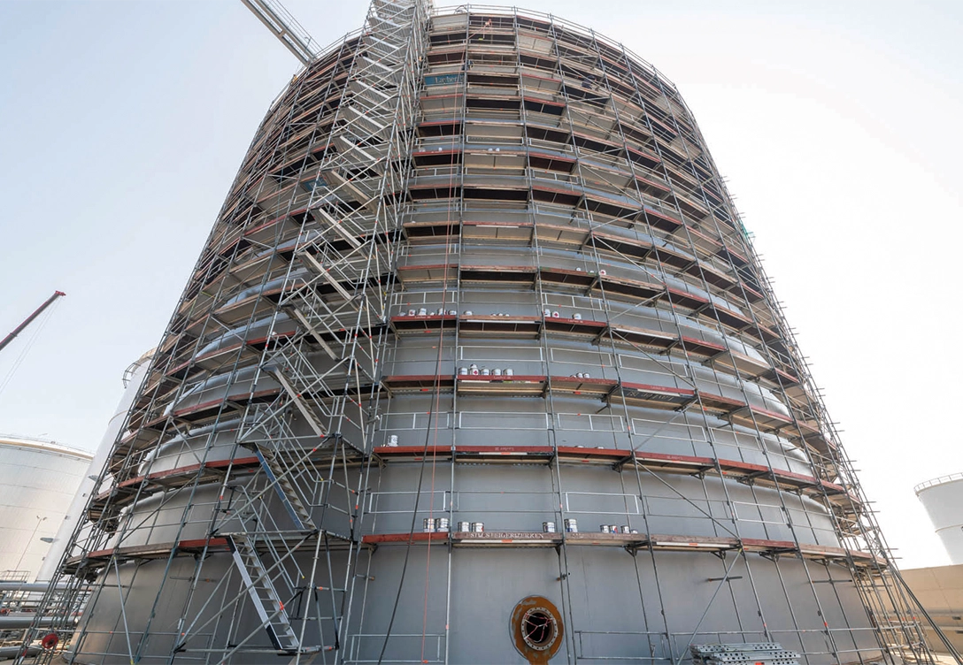 One of the six newly constructed cone-roof storage tanks with scaffolding during the coating process.