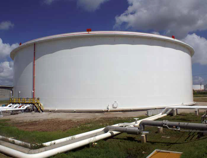 A large white storage tank at a major US refinery with pipelines running along the ground.