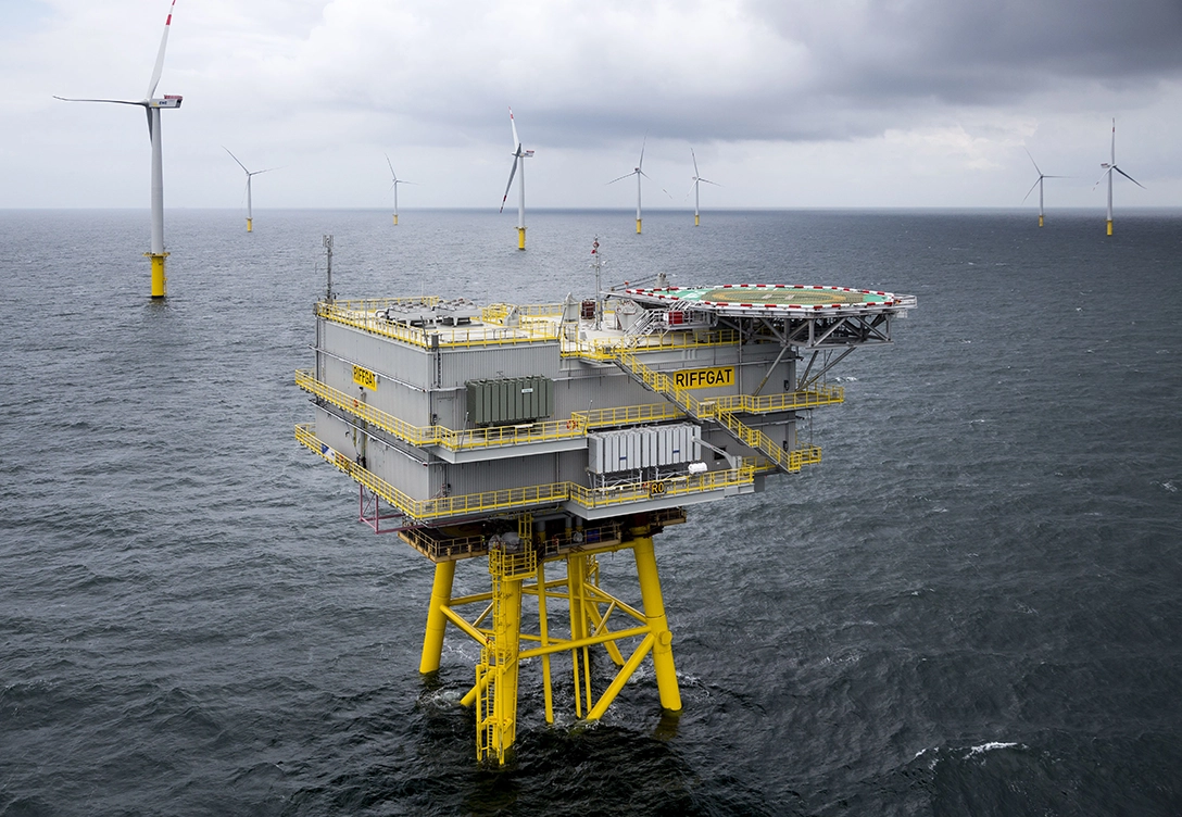 An offshore wind substation platform and wind turbines at the wind farm in China sea.