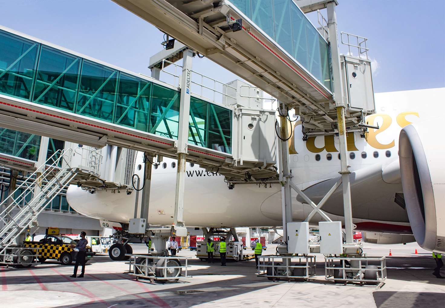 Adelte boarding bridges connected to an aircraft, loading passengers.