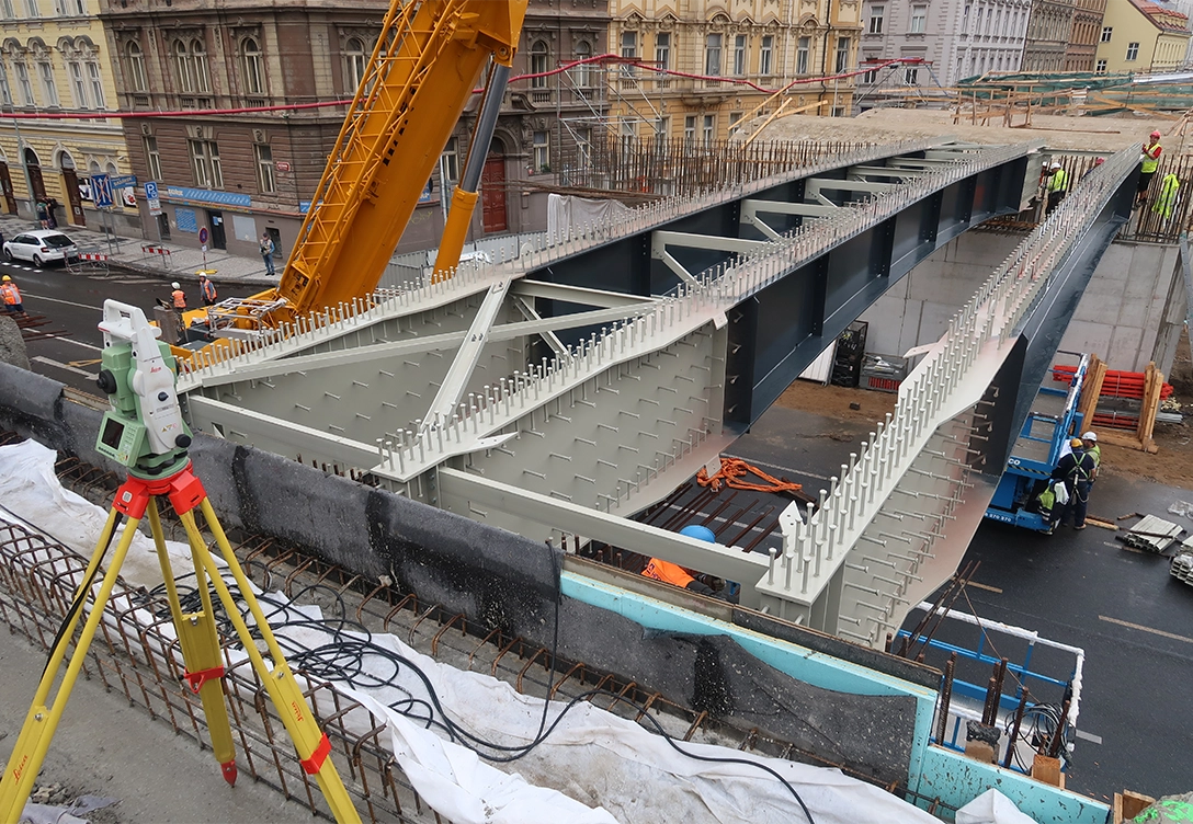 Construction site with workers installing a large steel girder as part of the Horin Road Bridge.