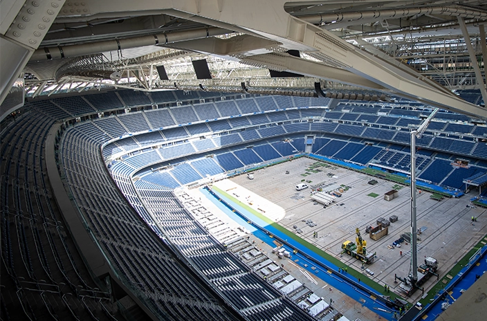 An overhead view of Santiago Bernabéu Stadium with construction equipment spread across the field as renovations take place.