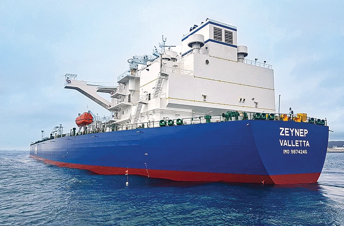 The vessel "Zeynep Valetta" from Ciner Shipping is shown at sea, featuring a blue and red hull with a large white superstructure and safety equipment visible on deck.