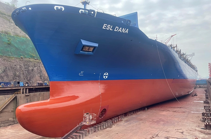 The container vessel "ESL Dana" from Peter Döhle Schiffahrts-KG is shown in a dry dock, featuring a blue and red hull resting on supports.
