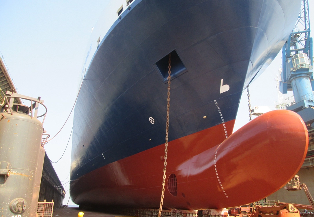 The bow of a U.N. Ro-Ro vessel with a blue and red hull coated by Hempel's Hempaguard X7 coating.